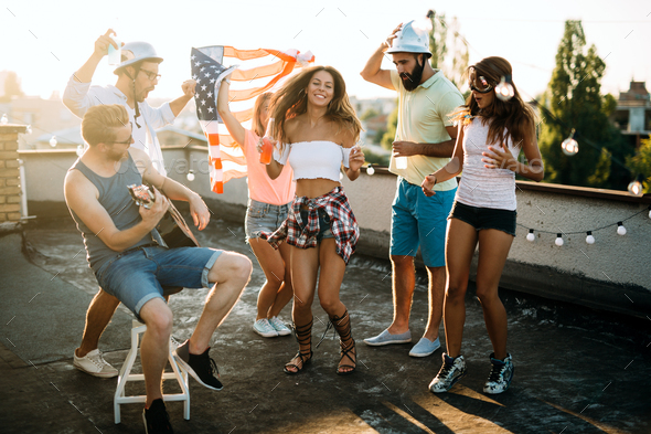 Group Of Young People Having Fun At A Summertime Party At Sunset Stock